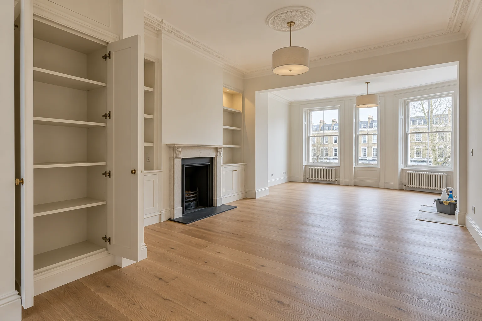 Empty renovated living room with an open fitted cupboard